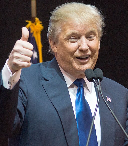 Donald Trump giving a thumbs up with a grin.